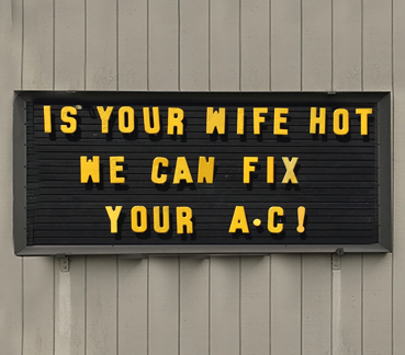 Outdoor sign with text: IS YOUR WIFE HOT - WE CAN FIX YOUR A.C!